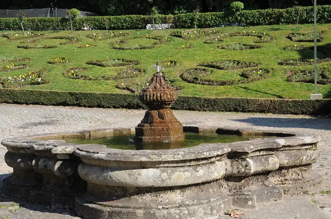 The formal garden and its fountain on the terrace behind the church