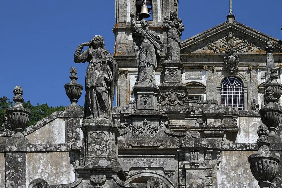 Granite figures and urns on the stairway against a clear sky
